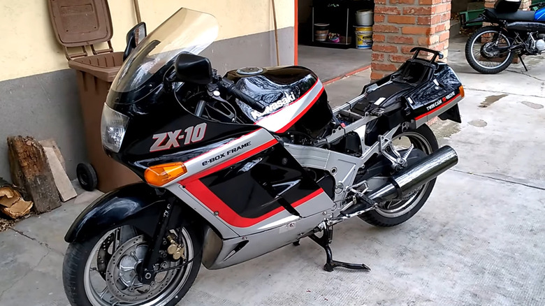 A late-1980s black, red, and silver Kawasaki ZX-10 Tomcat motorcycle resting on its center stand.