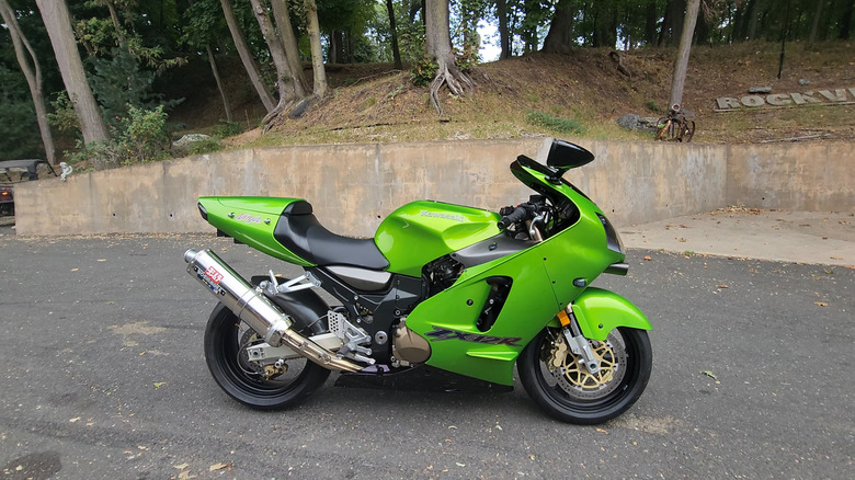 A lime green Kawasaki Ninja ZX-12R hyperbike featuring a Yoshimura exhaust, parked in side profile outdoors.