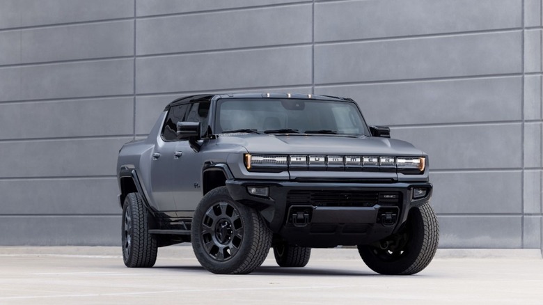 A grey GMC Hummer EV pickup parked by the side of the building