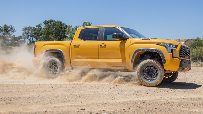 A side view of a Honeycomb Tundra TRD Pro sliding through dry dirt on a sunny day