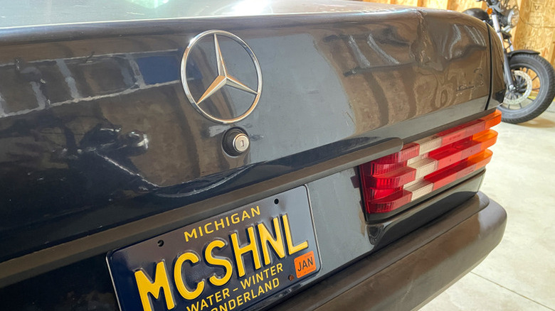 The trunk/rear of a 1989 Mercedes-Benz 190E in a garage.