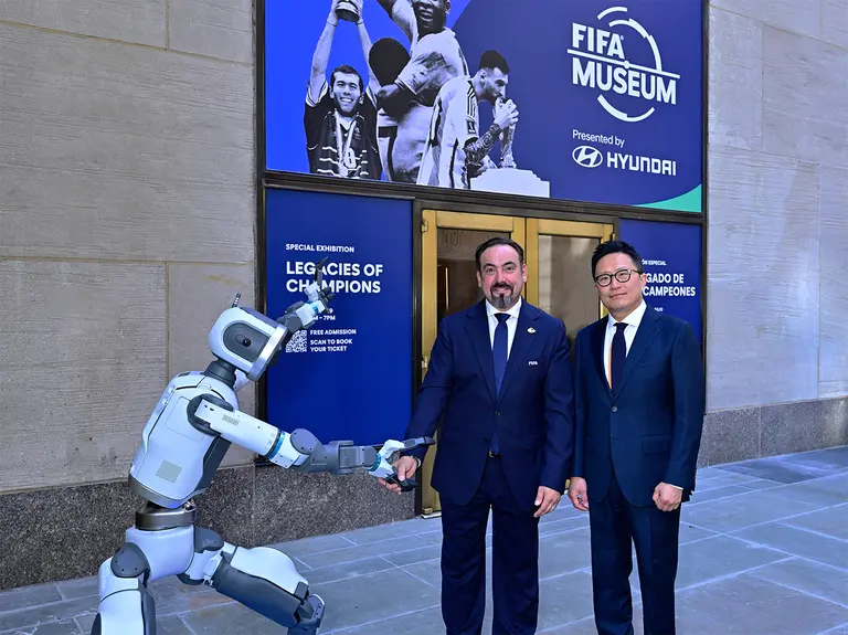 Marco Fazzone (left), Director of the FIFA Museum, and Ji Sung-won, Executive Vice President and Head of Hyundai Motor's Brand Marketing Division, taking a commemorative photo with Atlas at the entrance of the FIFA Museum