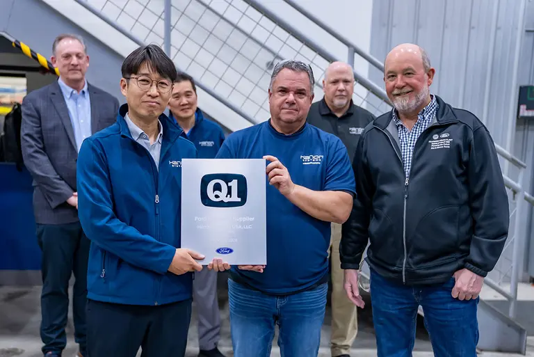 Seok-ho Seong, Plant Manager of Carey (far left), Brandy Smith, Ford STA Engineer, and Brian Bank, Ford STA Site Manager, holding the Ford Q1 certificate
