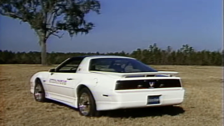 A white 1989 Turbo Trans Am parked in a field
