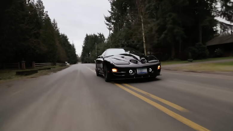 A black pontiac WS6 speeding down the road