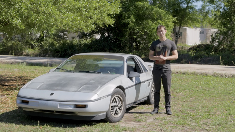 Silver Pontiac Fiero parked on grass