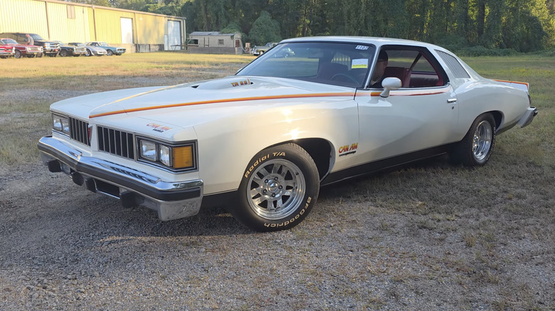 a white Pontiac Can Am parked in a field