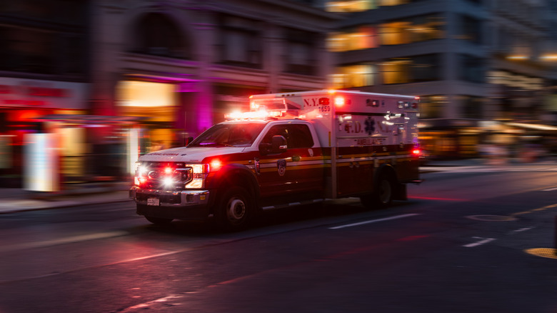 An ambulance speeding through a city street at night