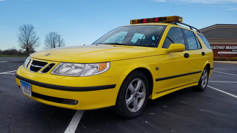 Front three-quarters shot of a yellow Saab 9-5 wagon SARSYS Friction Tester parked in a parking lot