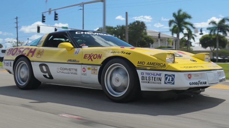 A yellow and white C4 Corvette Challenge race car with Exxon and Bosch sponsorship decals and the number 9, driving on a sunny street.