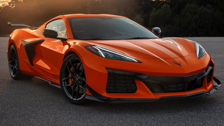 An orange C8 Corvette ZR1 parked on a wide asphalt track.