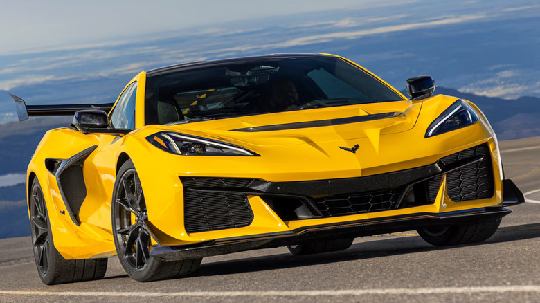 A bright yellow mid-engine C8 Corvette Z06 with the Z07 performance package wing, parked on a high-altitude mountain pass.