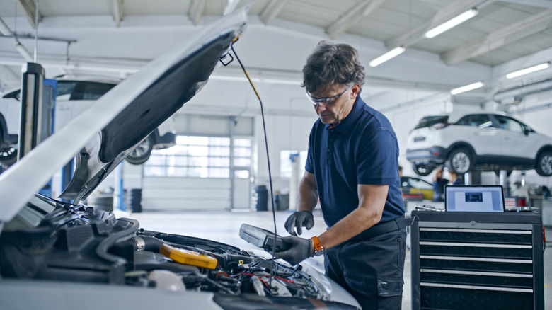 A mechanic in a big service garage working on a car.