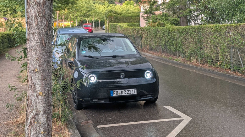A Honda e parked on a street in Germany