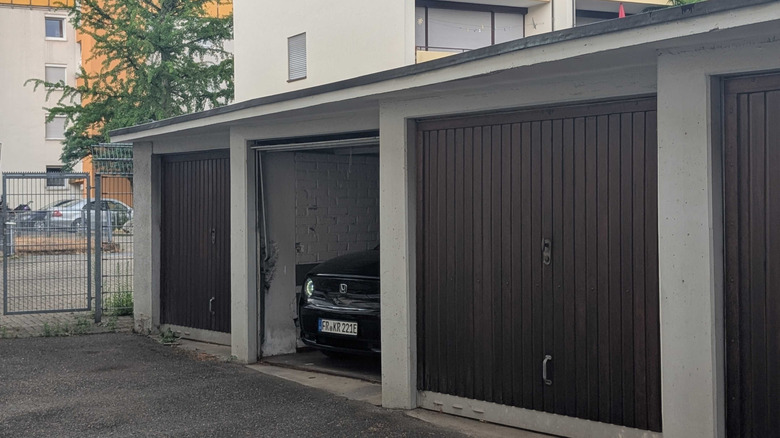 A Honda e peaking out from a garage