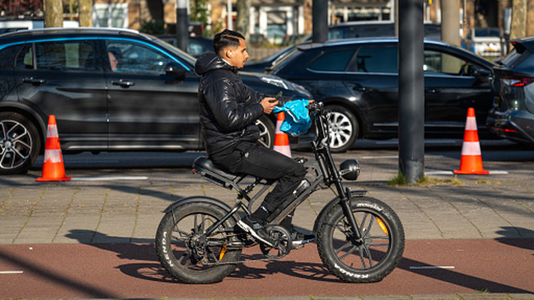 A youth rides an electric fatbike in a bike lane in Amsterdam