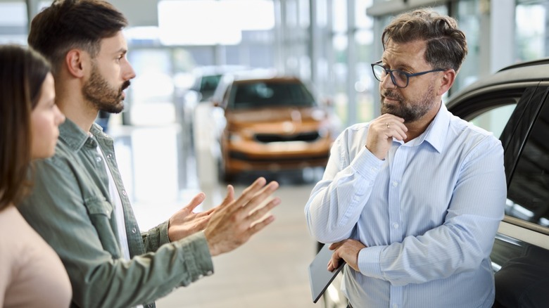A couple arguing with car salesperson