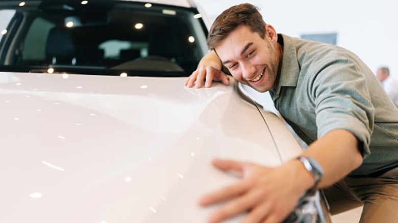 A man admiring and stroking a car