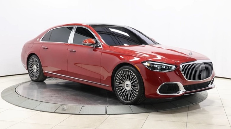 A front 3/4 view of a red 2021 Mercedes-Maybach S580 on a rotating turntable