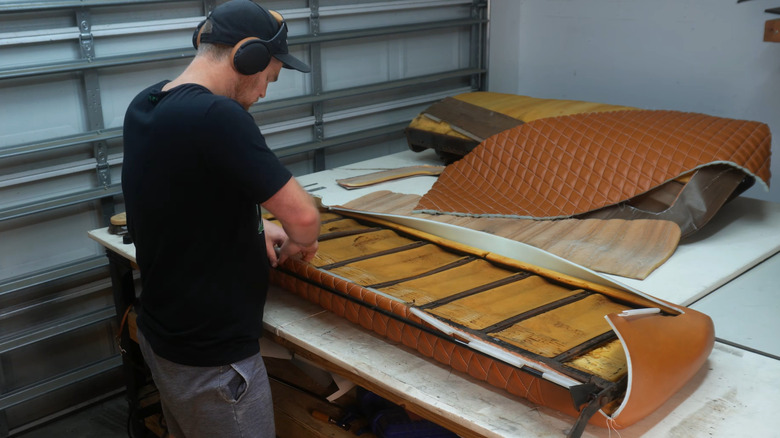 Man recovering the bench seat of a Ford truck in quilted brown leather