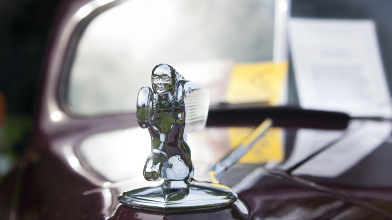A "donut chaser" or Goddess of Speed hood ornament graces the hood of an older Packard .