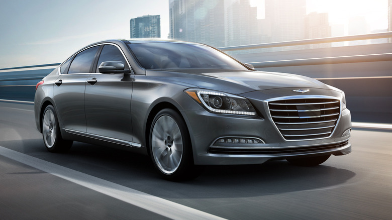 Front-right 3/4 view of a gray 2015 Hyundai Genesis driving on a road