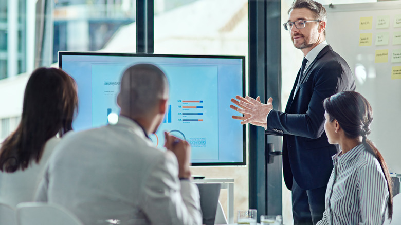 A man in a suit delivers a business presentation.