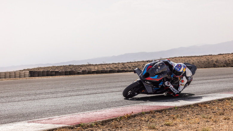 A rider on a BMW M1000RR takes a corner on track